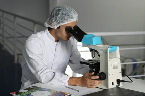 Scientist in lab coat analyzing samples with microscope, Magnascent Iodine research concept