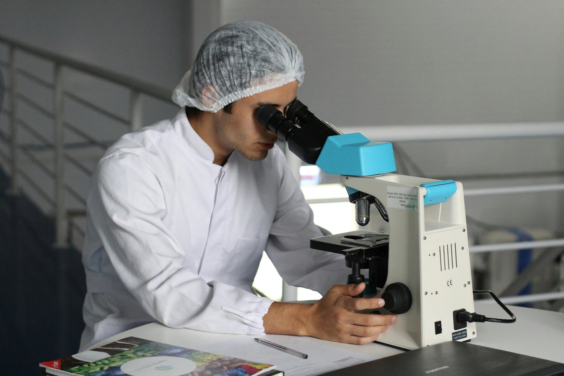 Scientist in lab coat analyzing sample with microscope, Magnascent Iodine research setting